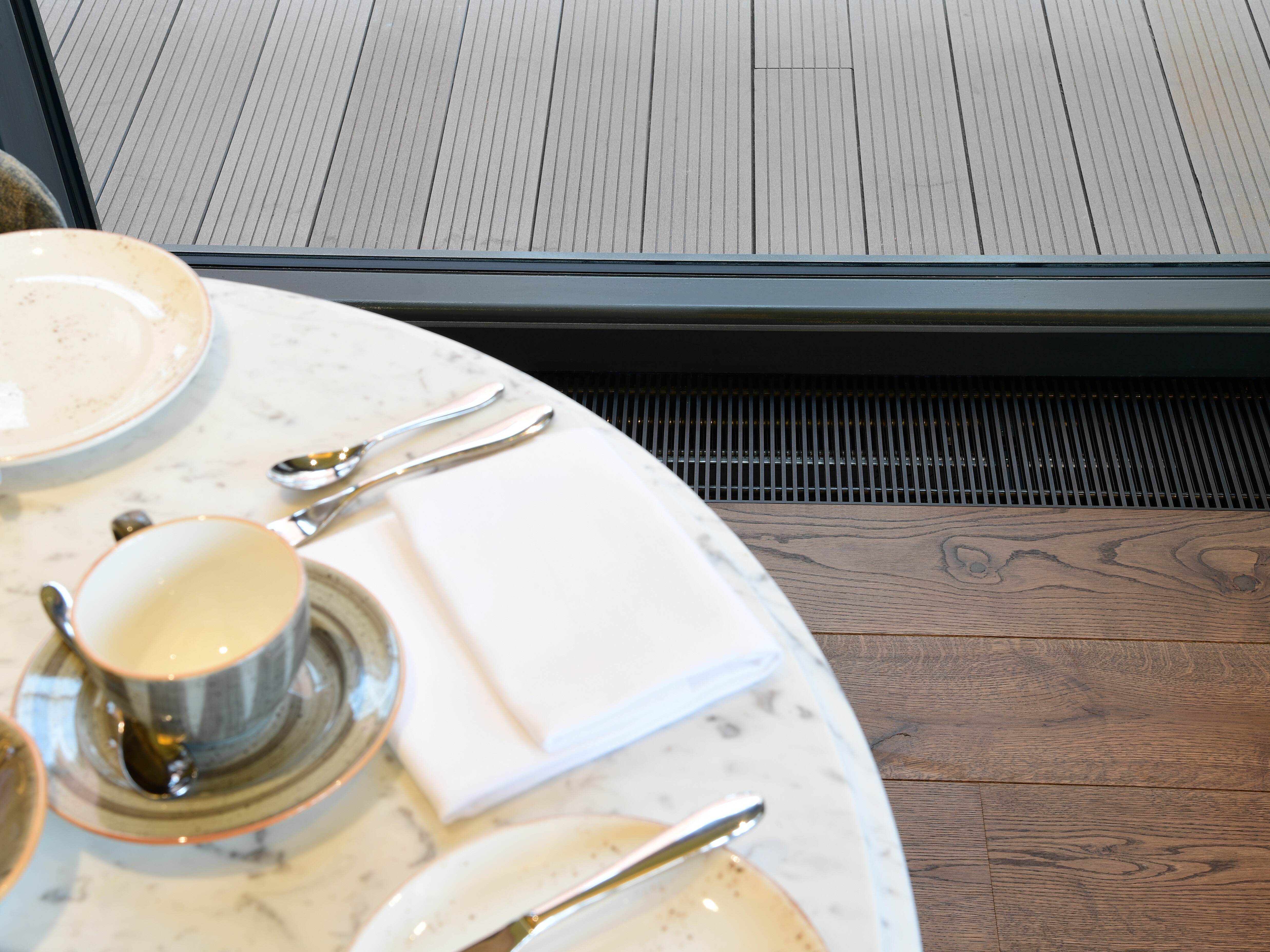 SPC trench heating running along the glazing beside a restaurant table at The Grand York Hotel